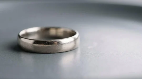 Gros plan d'une bague en or blanc présentant un début de jaunissement après plusieurs années de port quotidien