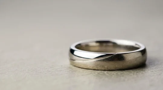 Bague en or blanc montrant la patine naturelle après le port quotidien, illustrant le jaunissement progressif du rhodiage usé