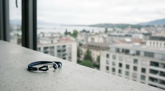 Bracelet ancre marine minimaliste posé sur fond urbain épuré avec espace négatif