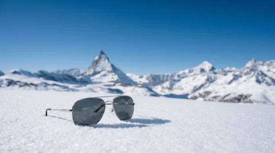 Lunettes de soleil sur neige de montagne en Suisse avec reflets lumineux naturels
